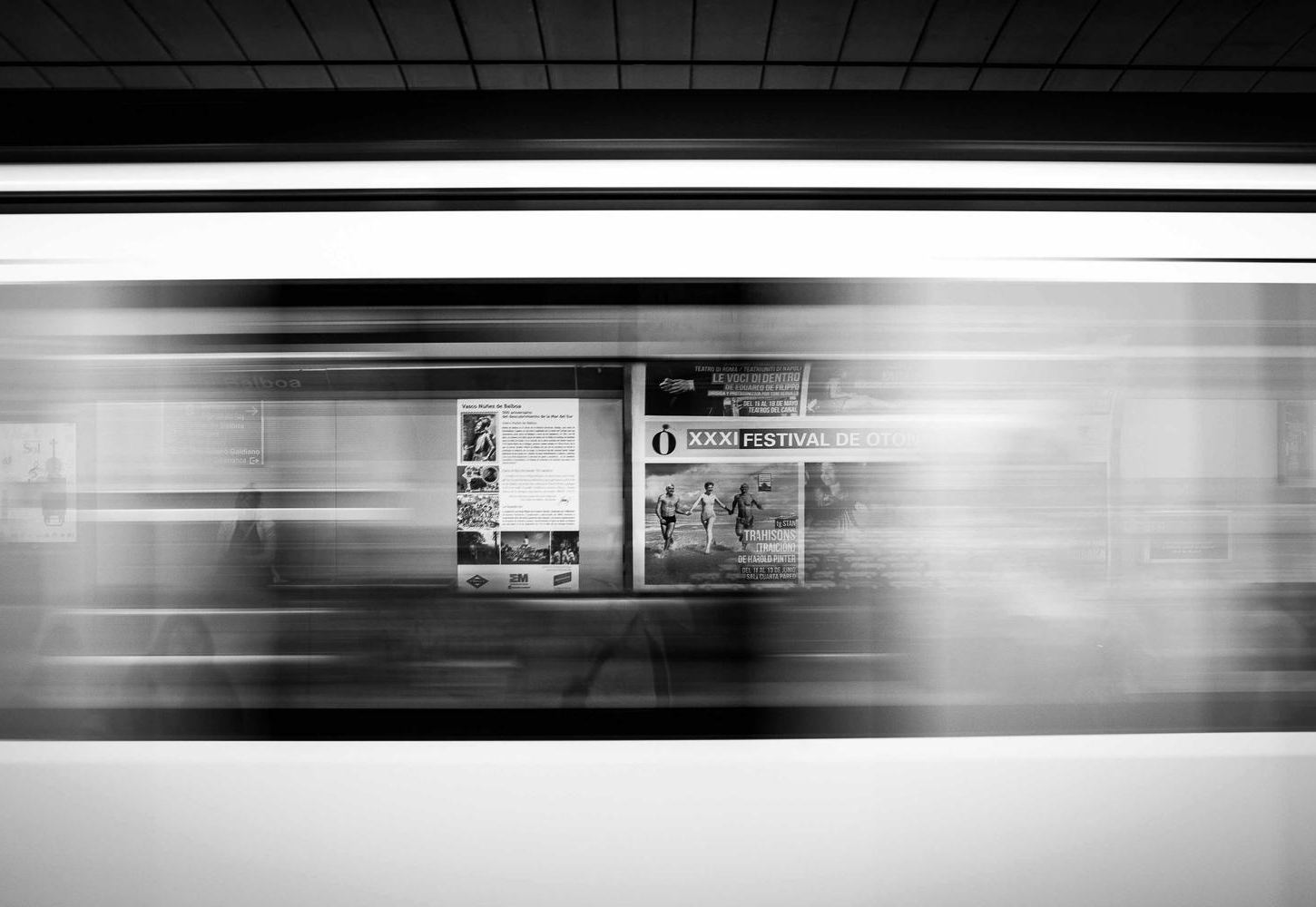 Pro metro stotį pralekiantis traukinys, nufotografuotas ilgu išlaikymu
